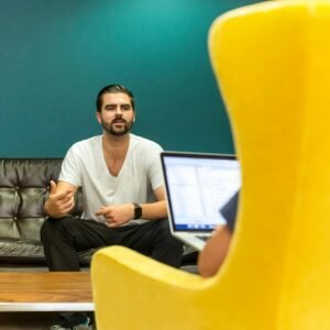 Casual office meeting with professionals discussing business ideas in a modern, comfortable setting.