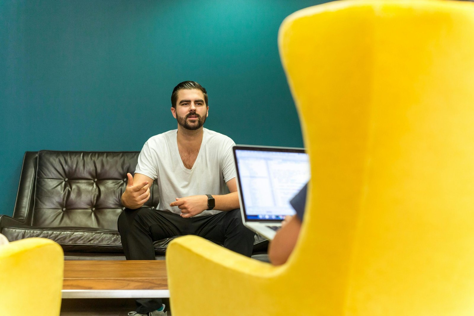Casual office meeting with professionals discussing business ideas in a modern, comfortable setting.